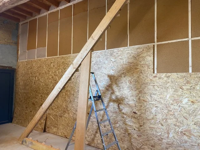 Mur en cours de doublage : ossature bois, isolant et panneaux