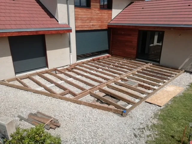 Structure de terrasse en bois posée sur le gravier
